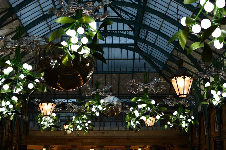 Giant mistletoe with white bulbs, silver bows, mirror balls and lanterns hanging under the market's glass roof