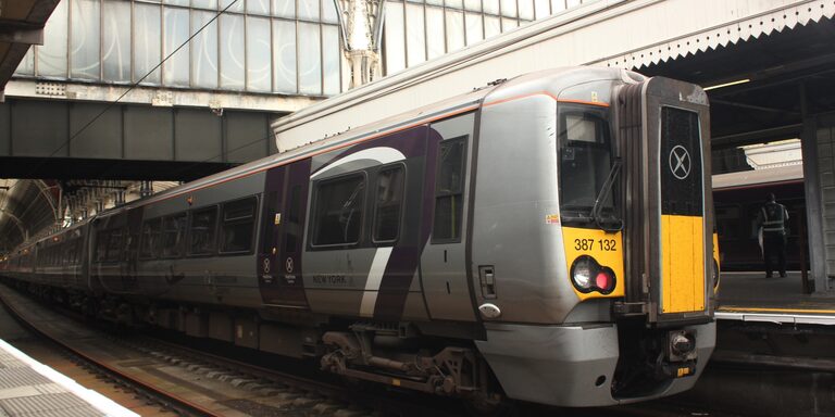 The front of a silver and purple Heathrow Express train at a platform in London Paddington station