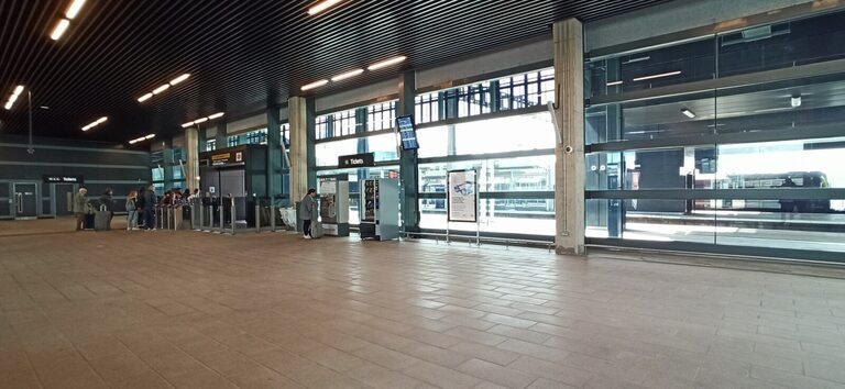 A ticket machine under a "Tickets" sign in the Luton DART's station at Luton Airport Parkway, with ticket barriers to the left