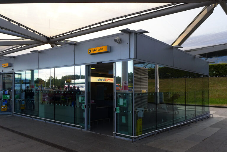 National Express's glass-fronted ticket office at Stansted Airport's coach station, with a "Ticket sales" sign above the door