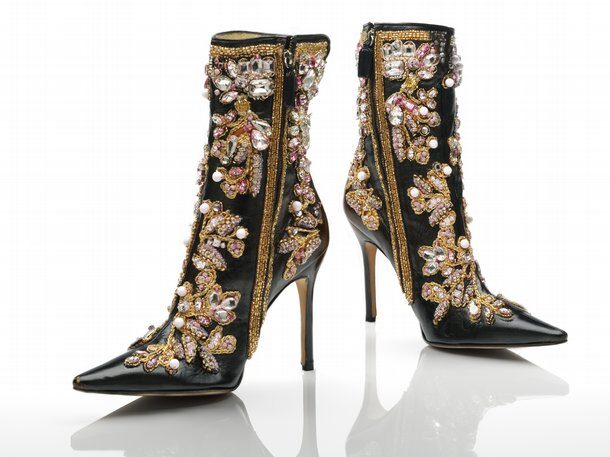 A pair of black stiletto ankle boots covered in gold, white and pink embroidery and jewels
