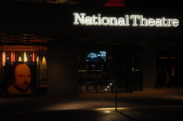 The National Theatre's lit-up name over its entrance at night